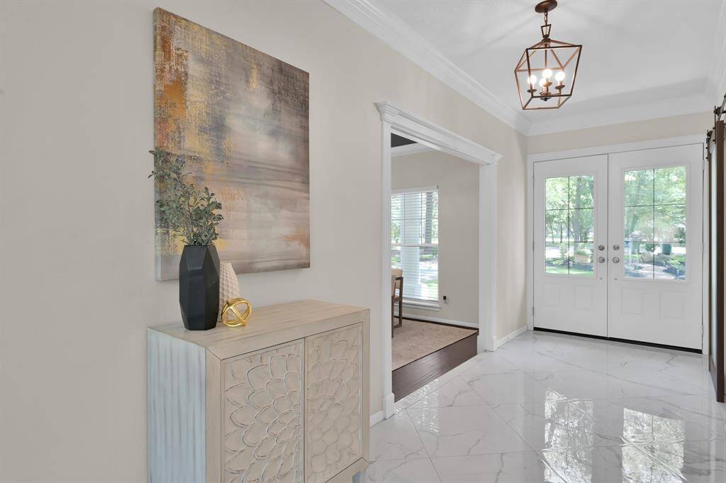Polished floors and designer lighting elevate this elegant transition space—setting the tone for luxury at every turn.