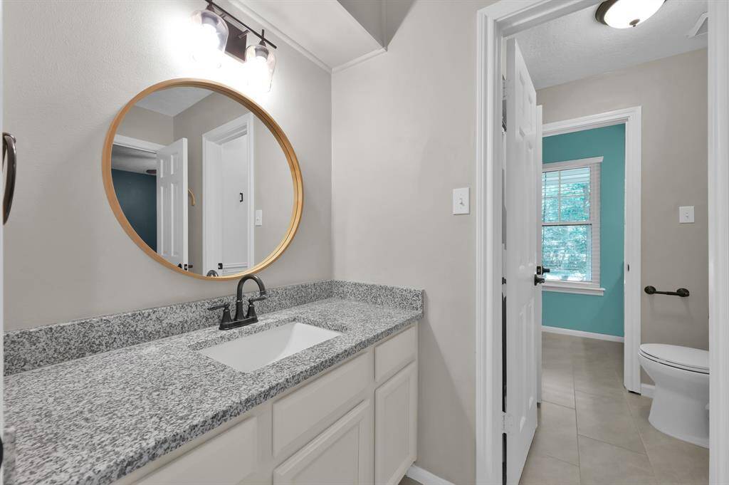 This thoughtfully designed Jack-and-Jill bathroom features granite countertops, modern fixtures, and private access from both bedrooms—combining style and shared convenience with upscale finishes.