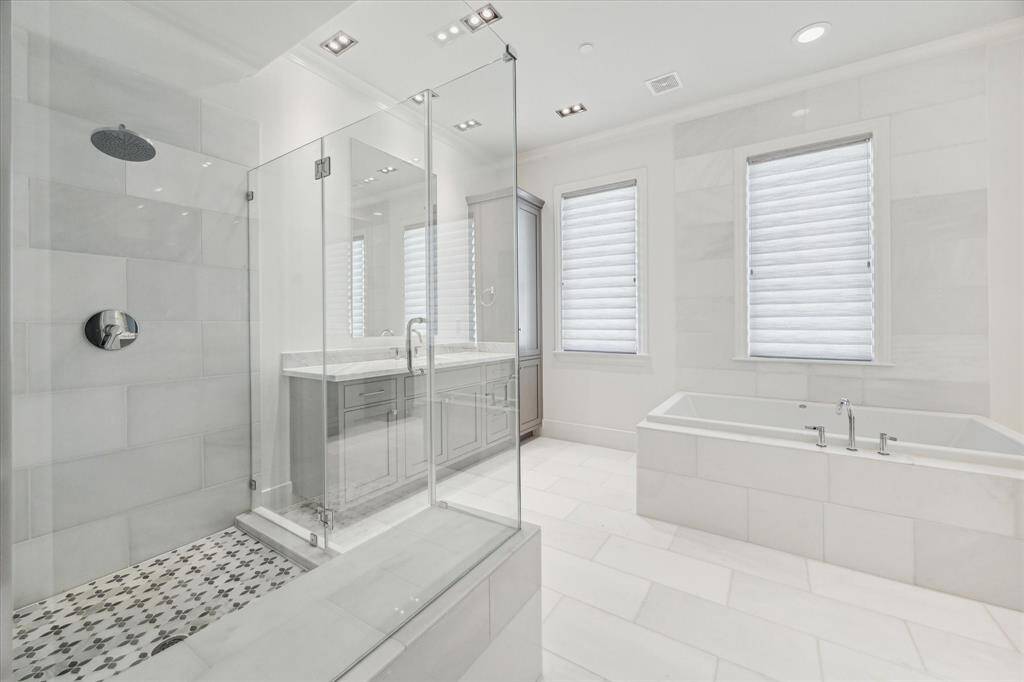 The spa-like and serene primary bath has natural light and elegant finishes, including an oversized tub and shower.  The tile in the shower provides a pop of sophisticated interest.