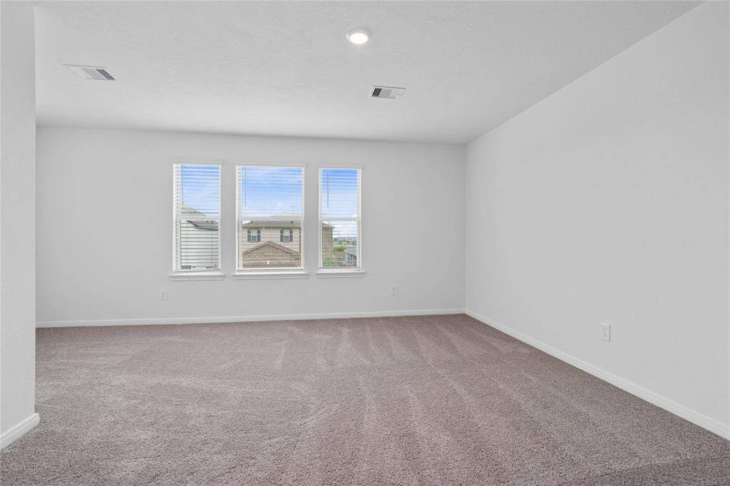 Come and unwind after a long day in this magnificent primary suite! This spacious room features plush carpet, warm paint, high ceilings and large windows with privacy blinds.