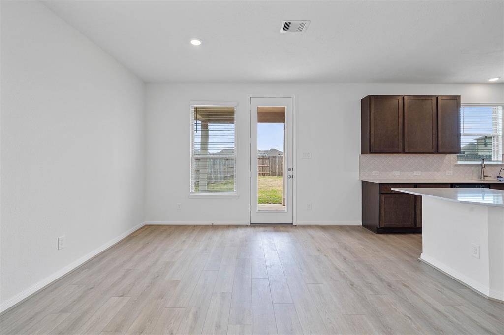 This lovely dining area is perfect for starting the day out on the right foot! This space showcases custom paint, high ceilings, recessed lighting, large window, and access door to your back yard and covered patio!