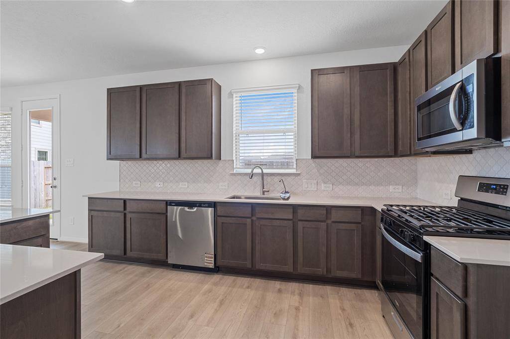 This kitchen is by far any chef’s dream! This spacious kitchen features high ceilings, recessed lighting, Woodmont Dakota Shaker panel cabinets, Silestone countertops, Whirlpool stainless steel appliances, modern tile backsplash, extended counter space for breakfast bar, and a pantry all overlooking your huge family room.