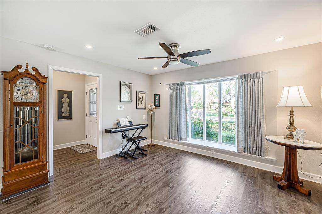 Dining room features lvp flooring, ceiling fan and large bay window looking out onto the front yard.