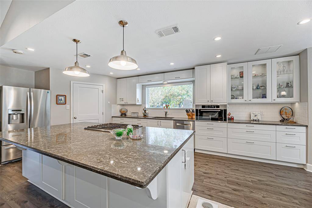 Updated kitchen features large kitchen island, quartz countertops, lvp flooring and convection oven.