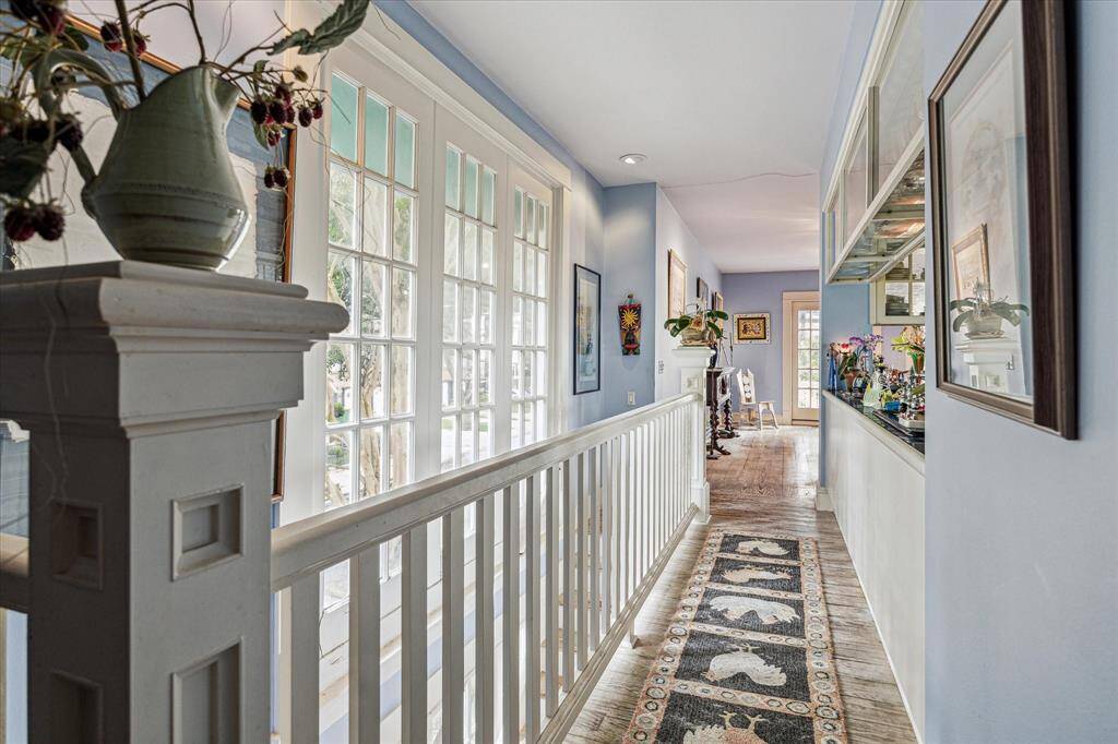 Second floor landing with hard wood floors, large windows and recessed lighting.