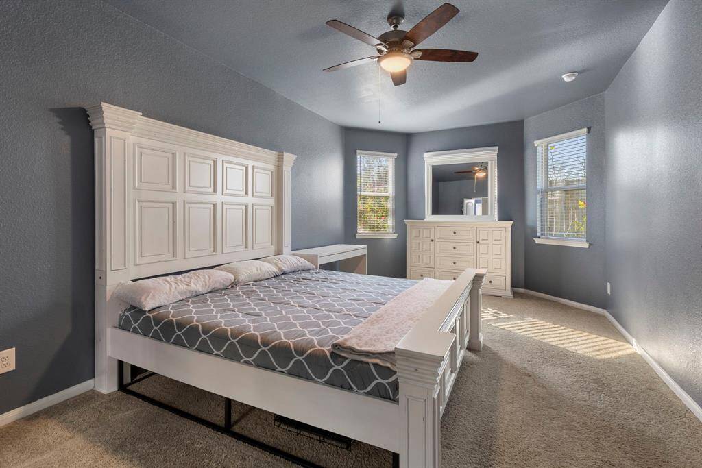 The primary bedroom is a true retreat with updated fan, plush carpet and sitting area with extended bay windows.