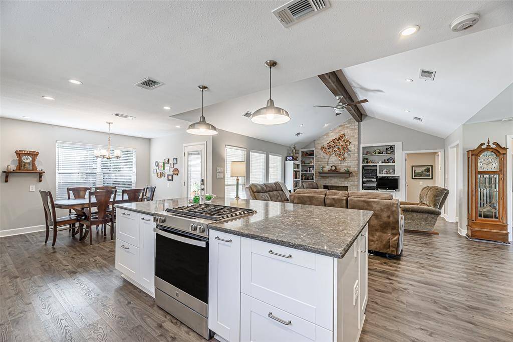 Kitchen island features tons of storage and ss gas range.