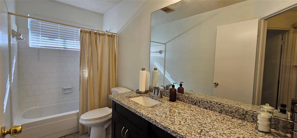 Shower and tub combo and natural light from  bathroom window.