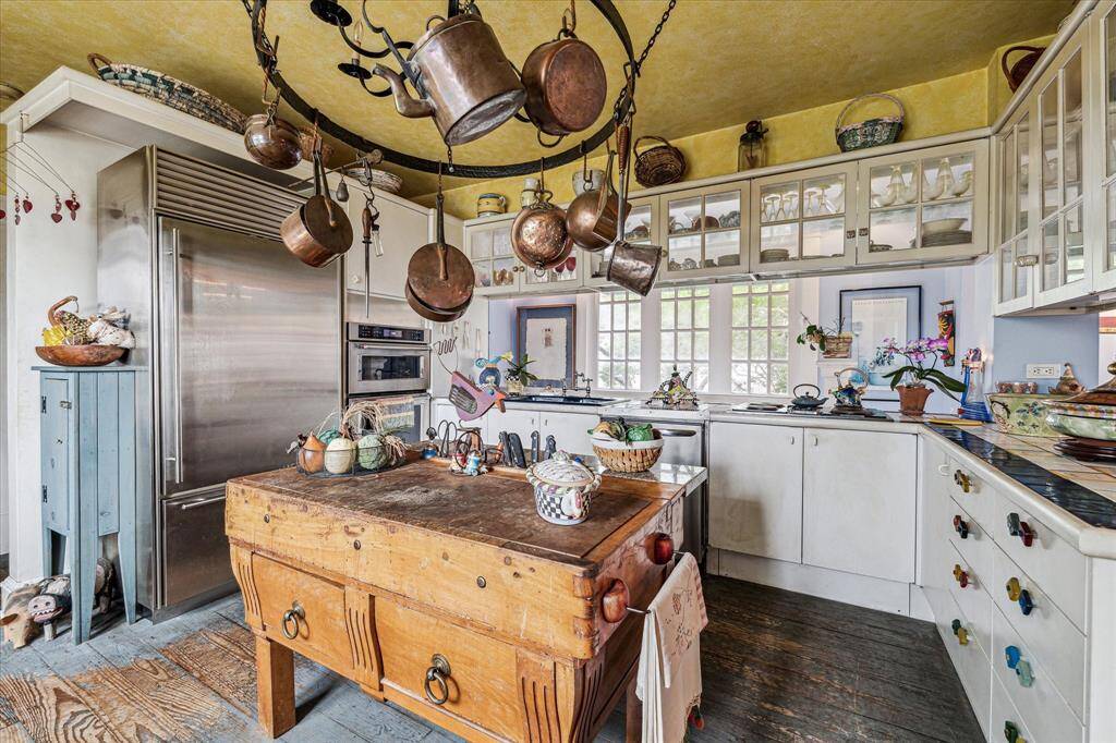 Kitchen with hardwood floors, tile counter tops and stainless steel appliances.
