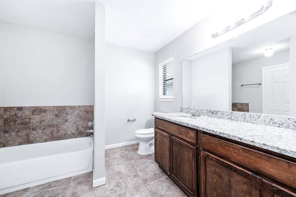 En suite primary bath featuring dual sinks and separate tub and standing shower.