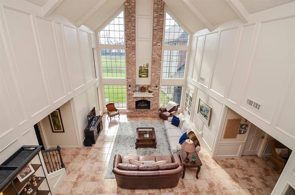 Beautiful view of the den with the two story windows flanking the fireplace.