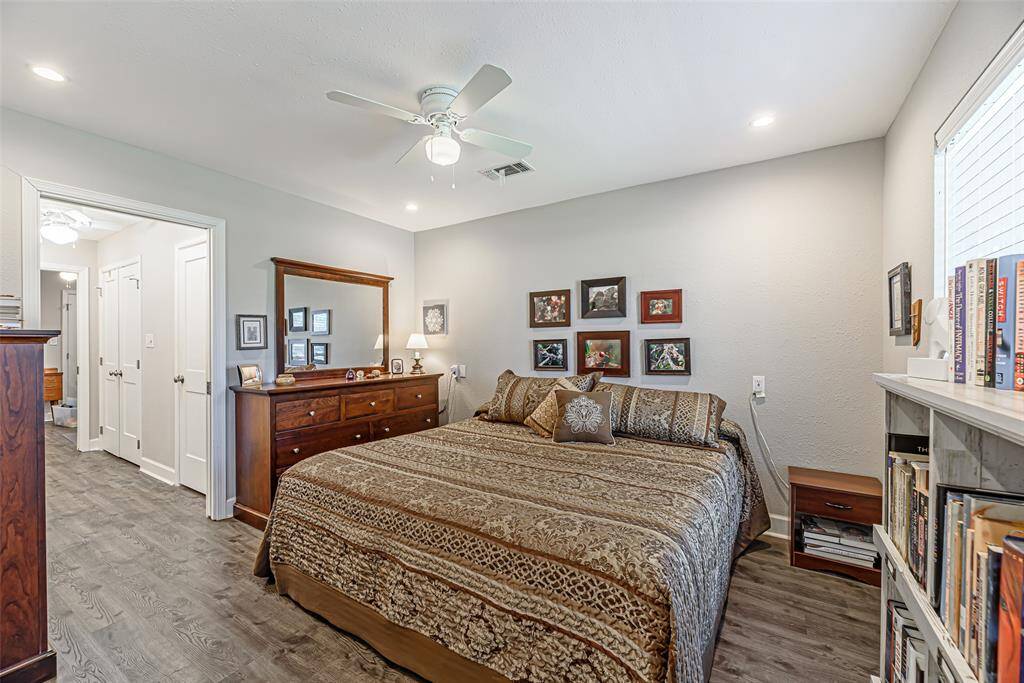 Primary bedroom has lvp flooring, canned lighting and ceiling fan.