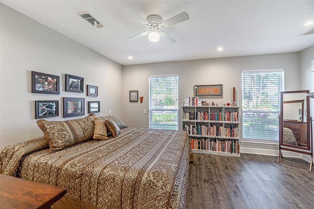Alternate view of primary bedroom with double picture windows overlooking the well maintained yard.