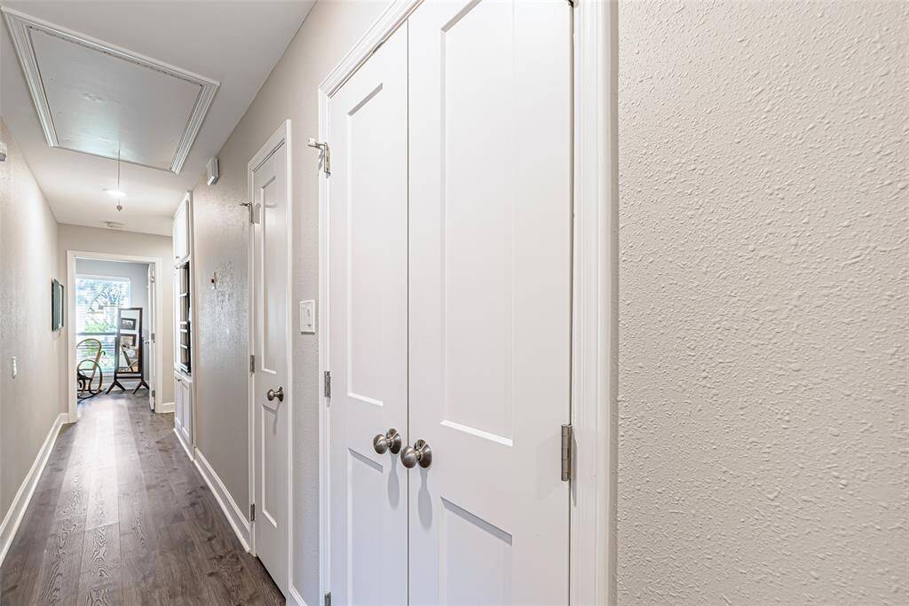 View of hallway with secondary bedrooms and extra storage in closets.