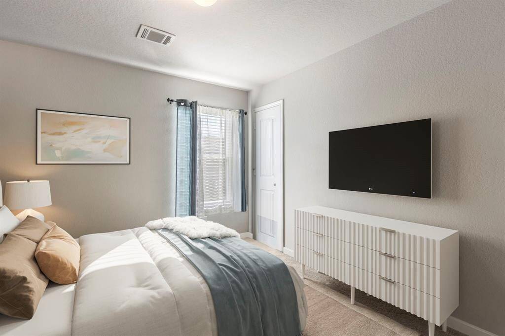 Secondary bedroom #1 has a large closet and is located towards the back of the home. *This image has been virtually staged.