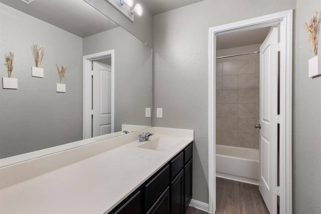 The full bath has a large vanity with plenty of counter space and private wet area with tub/shower combination with tile surround.