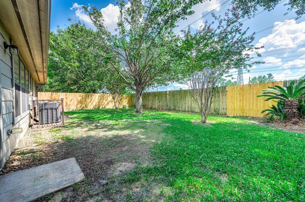Fully fenced backyard with mature tree for shade.