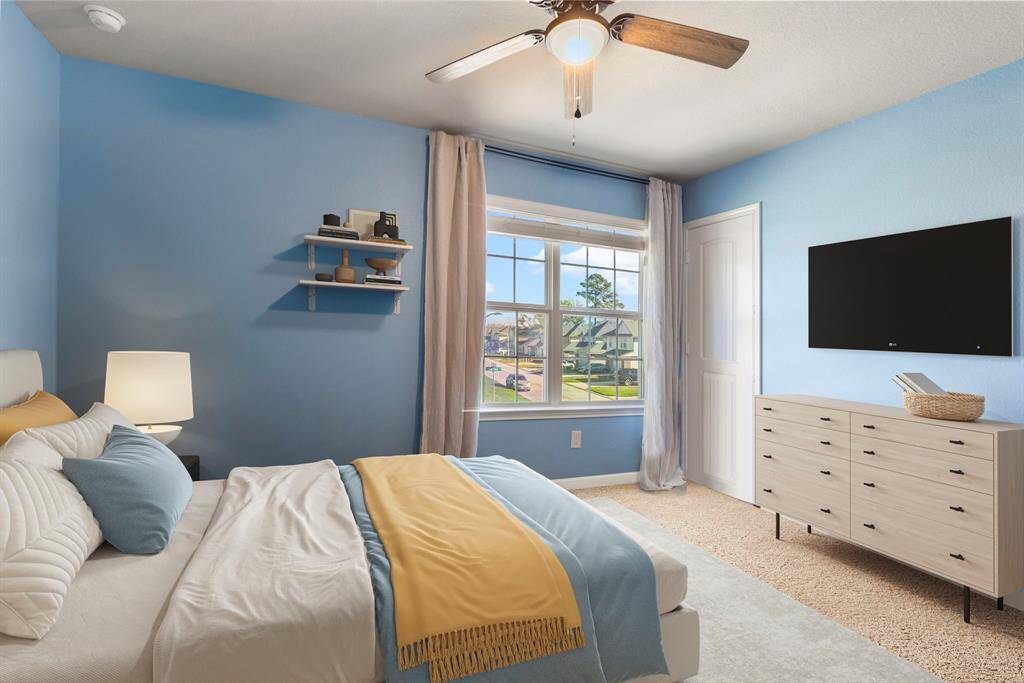 Secondary bedroom #3 is located towards the front of the home with updated ceiling fan and walk-in closet.  * This image has been virtually staged.