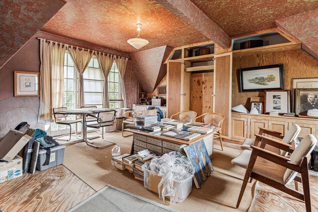 Third floor den with wood floors, pendant lighting and attic access.