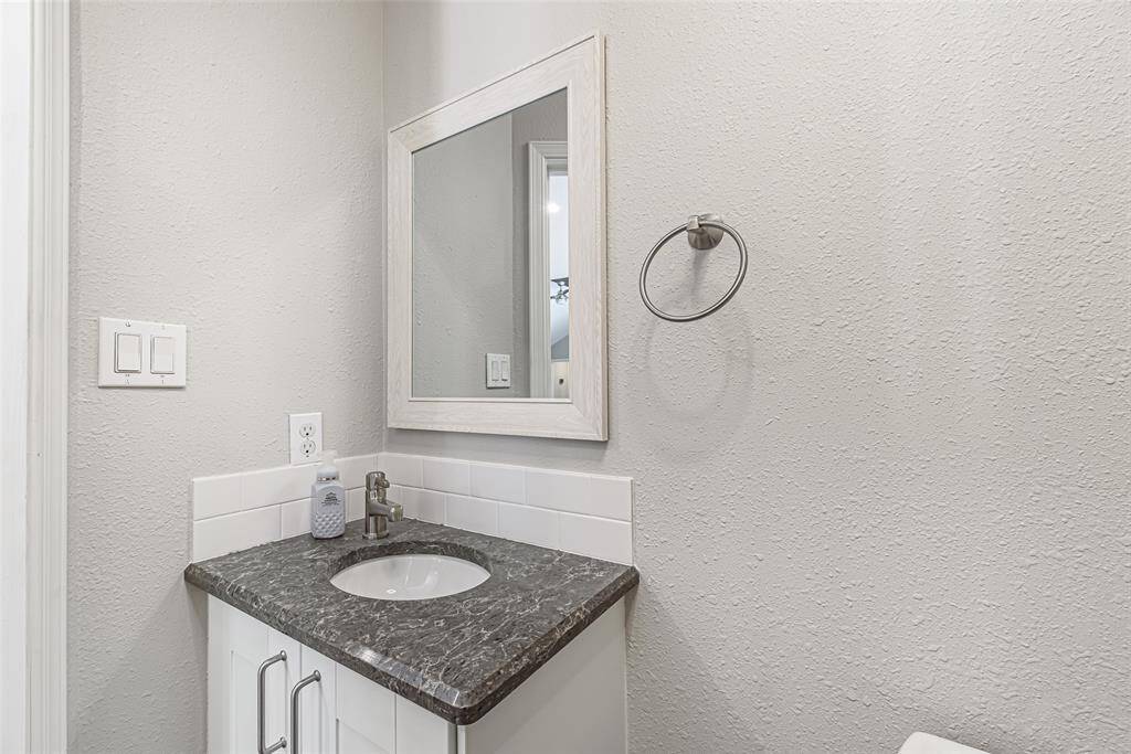 Half bath has quartz cabinets and round under mount sink.