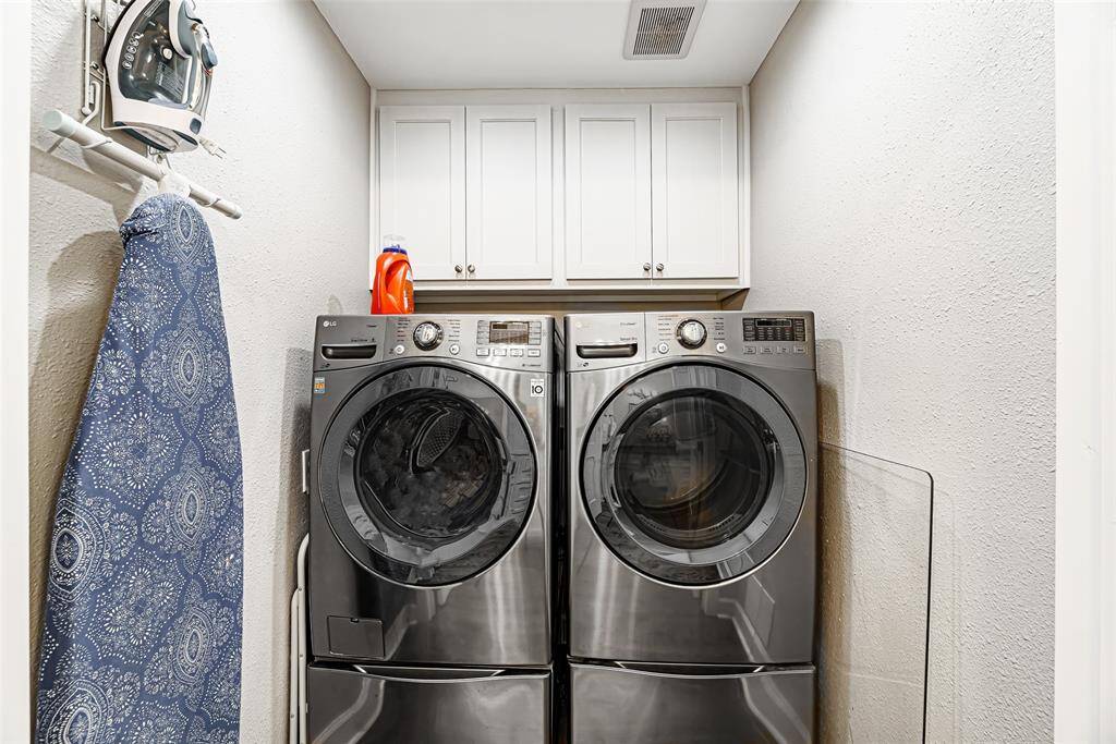 Utility room is located in the home and has cabinets for storage.