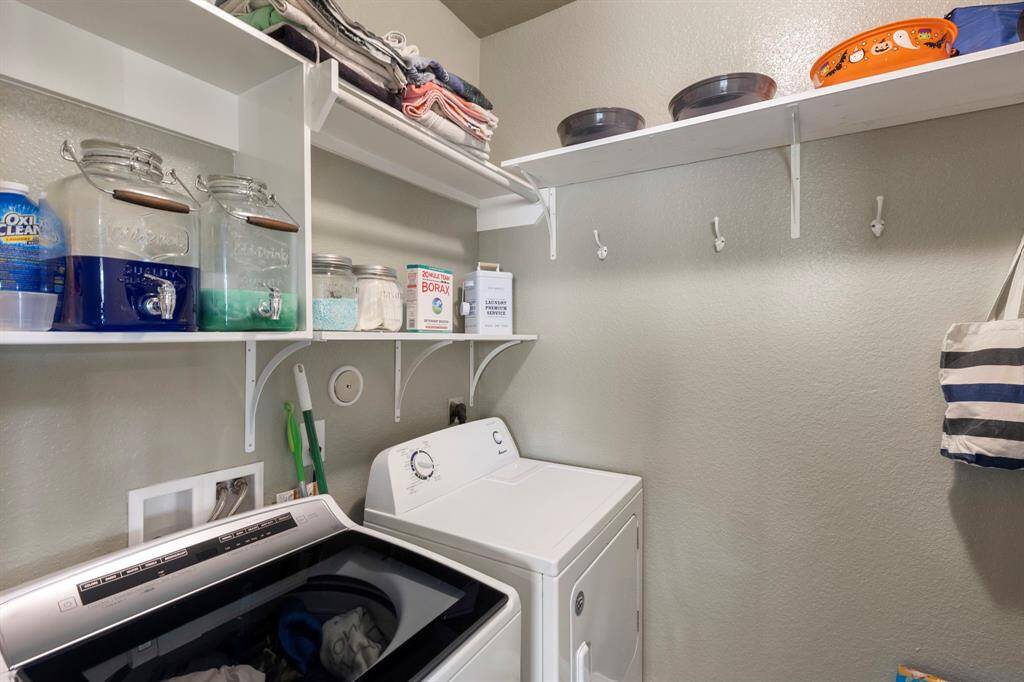 The generously sized laundry room is equipped with updated shelving and hanging space.  Enough space for an additional refrigerator or freezer! *Washer and Dryer Included