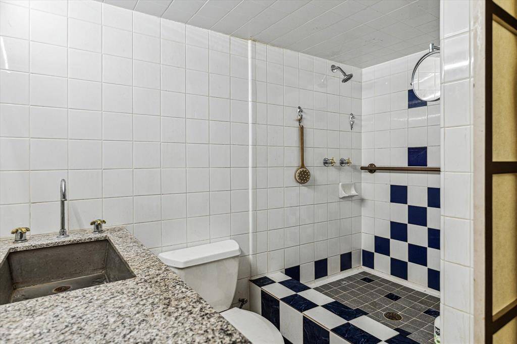 Secondary bathroom with a single sink and walk-in shower.
