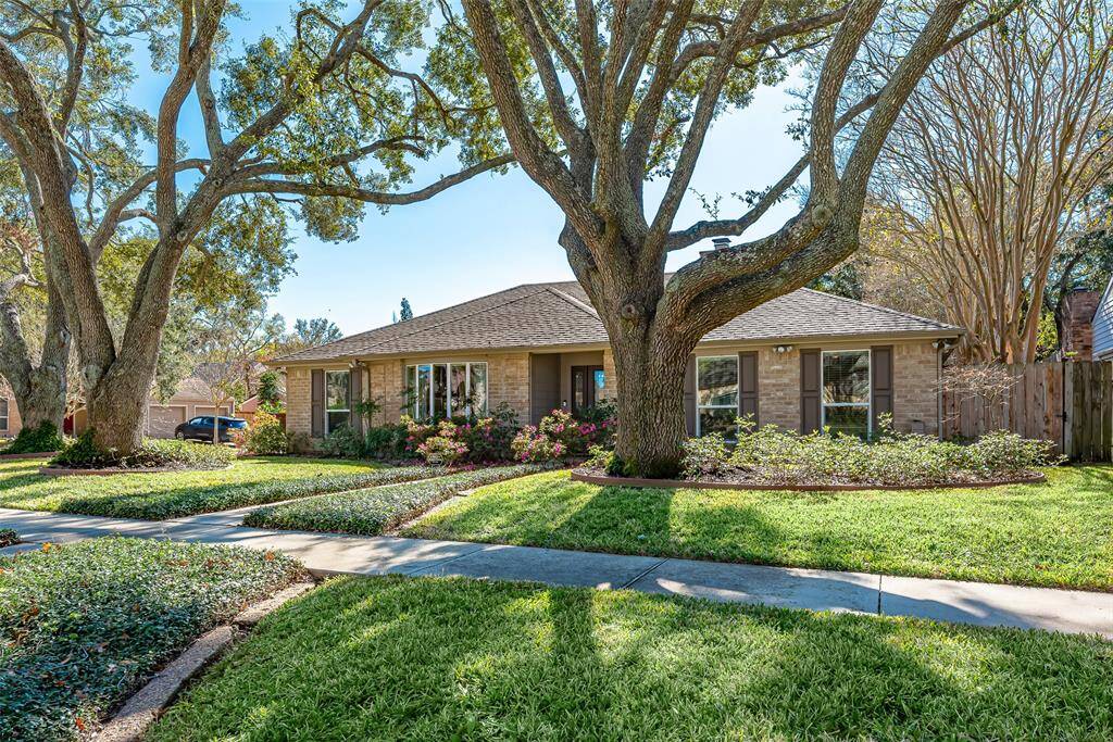 Front yard features mature trees and well maintained landscaping with sprinkler system.