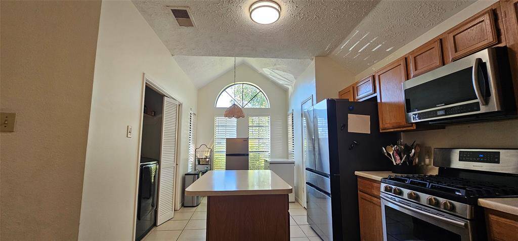The kitchen has a laundry area adjacent to it. The space is well-lit with a modern ceiling light.