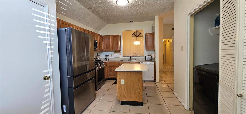 The kitchen has a laundry area adjacent to it. The space is well-lit with a modern ceiling light.