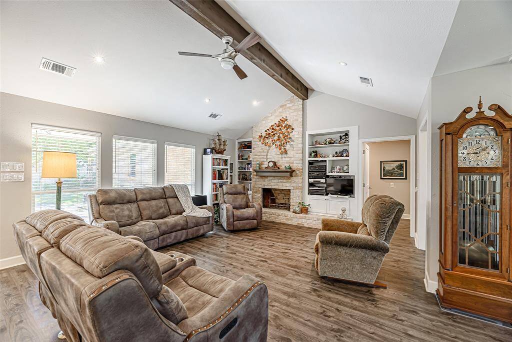 The family room features LVP flooring that is throughout the entire home and built-ins.