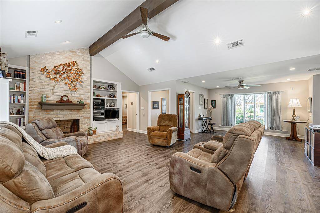 Family room also features a vaulted ceiling with large beam and canned lighting as well as a brick wood burning fireplace.