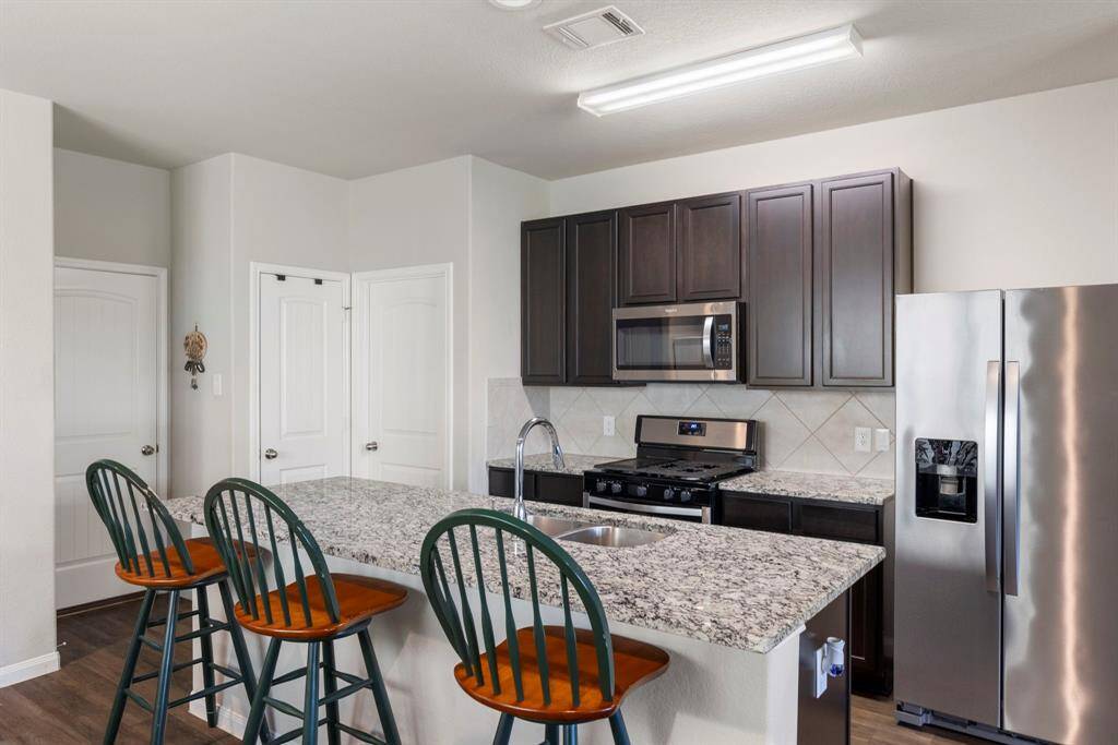 The gourmet kitchen offers a large working island with granite countertops and double stainless-steel sink and chrome faucet.   Kitchen has newly installed water softener!