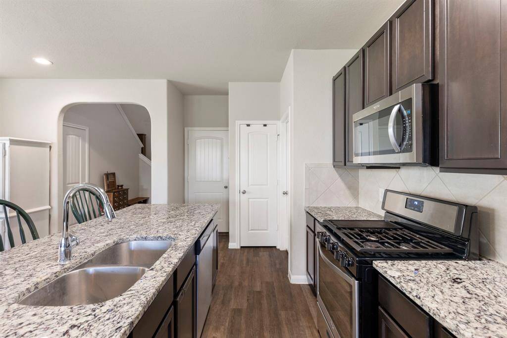 The cabinetry is rich in color and modern in design with flat panel fronts and 42" uppers. Energy Star appliances with vented microwave and 5-burner gas range.  The pantry offers additional storage.