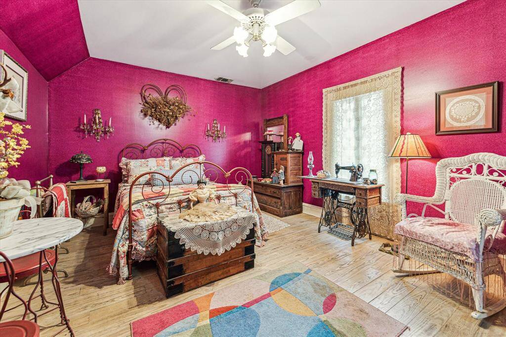 Secondary bedroom with hardwood floors, ceiling fan with lights, and is en suite.