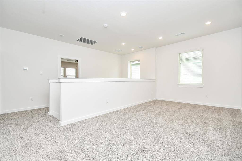 This versatile loft space, carpeted in soft gray, offers a cozy feel that seamlessly blends comfort and functionality. Whether you need a home office, a playroom, or simply a space to relax, this adaptable space can meet your needs.