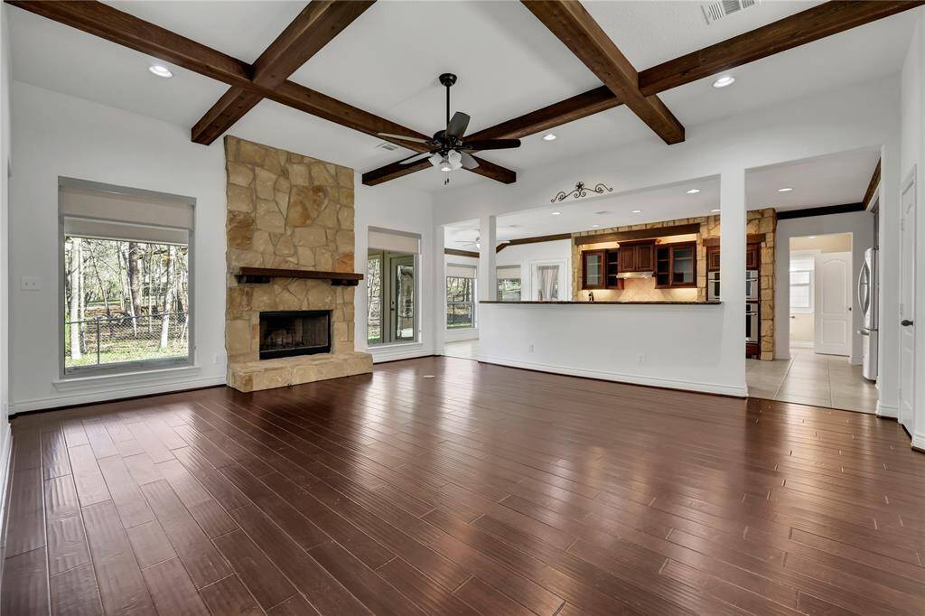 The living area has a wood beam accent ceiling - virtually staged