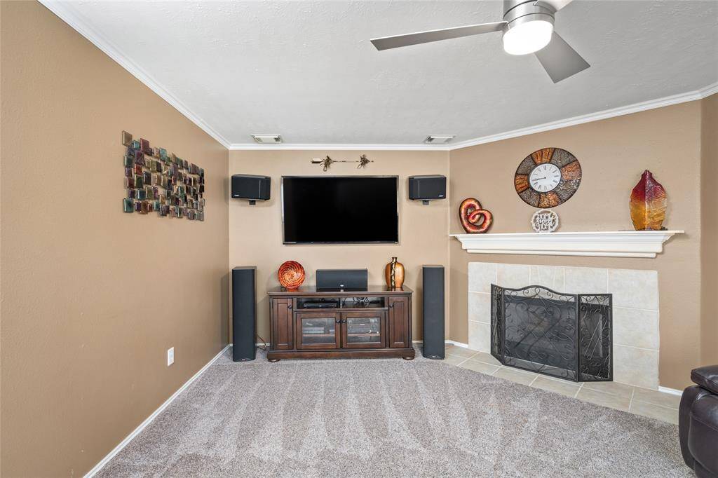 Your new living features a fireplace with tile surround and wood mantle and a warm color scheme.