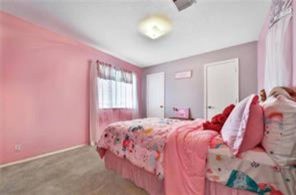 Spacious, carpeted upstairs game room with neutral walls, large window for natural light, and an overhead light fixture.