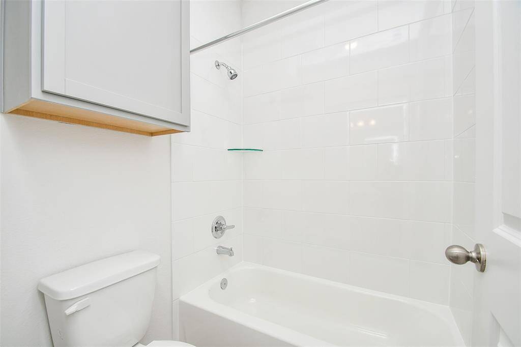 The secondary bathroom features a clean and practical design, complete with a shower/tub combo.