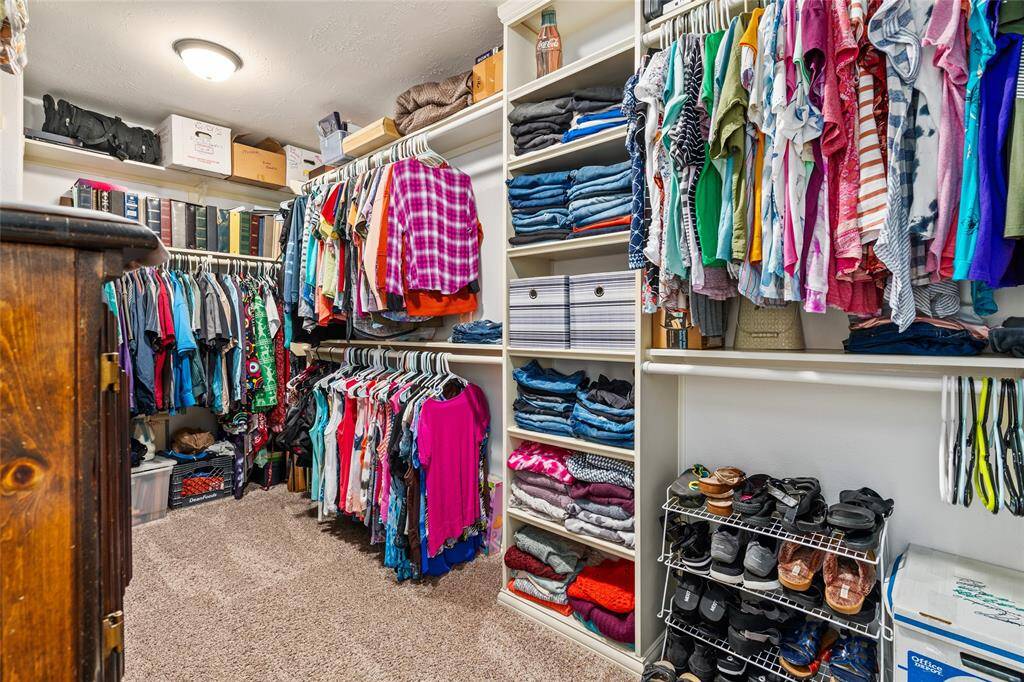 Your primary bedroom includes a spacious walk-in closet with built-in shelving and hanging rods offering ample storage for clothing, shoes, and accessories.