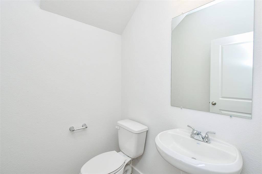 This convenient half bath on the first floor features a mirror and sink, providing a practical and stylish solution for guests and loved ones.