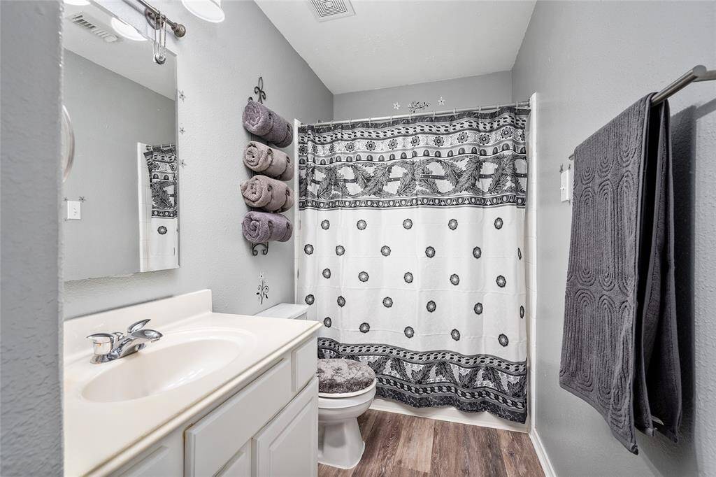 Your secondary bathroom features a single vanity with ample counter space, an undermount sink, a large mirror and a full-sized shower/tub. The room is finished with luxury vinyl flooring and a fresh, neutral paint color.