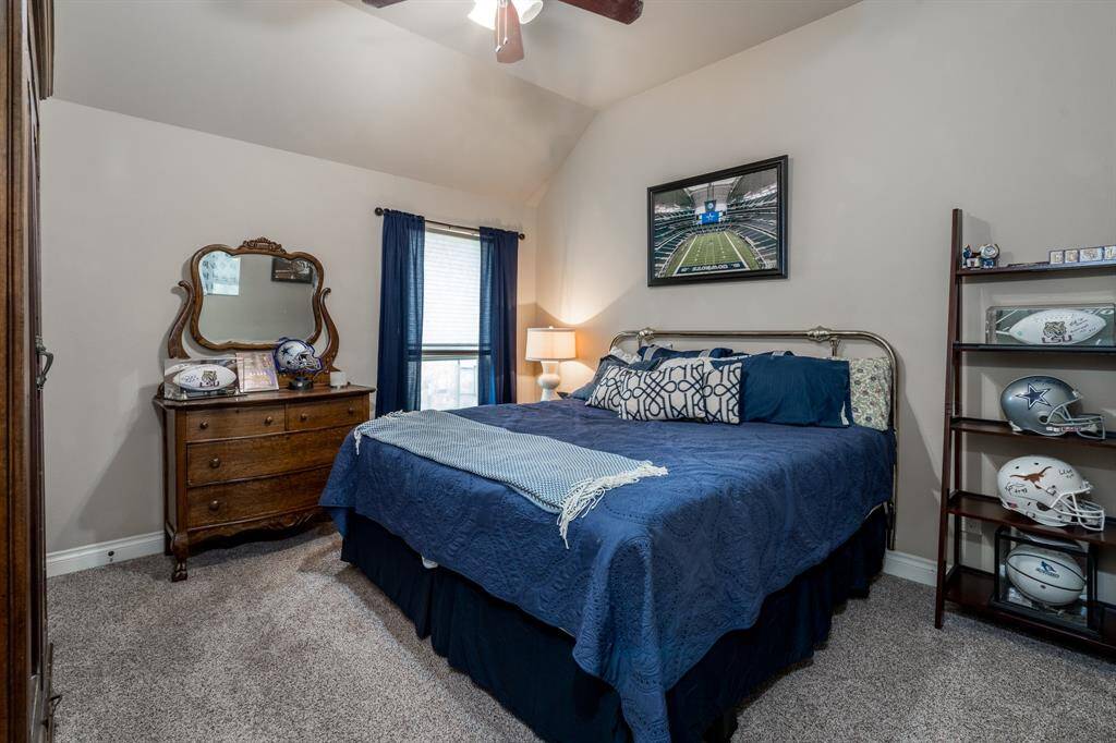 Secondary bedroom features a large window, ceiling fan, and carpet