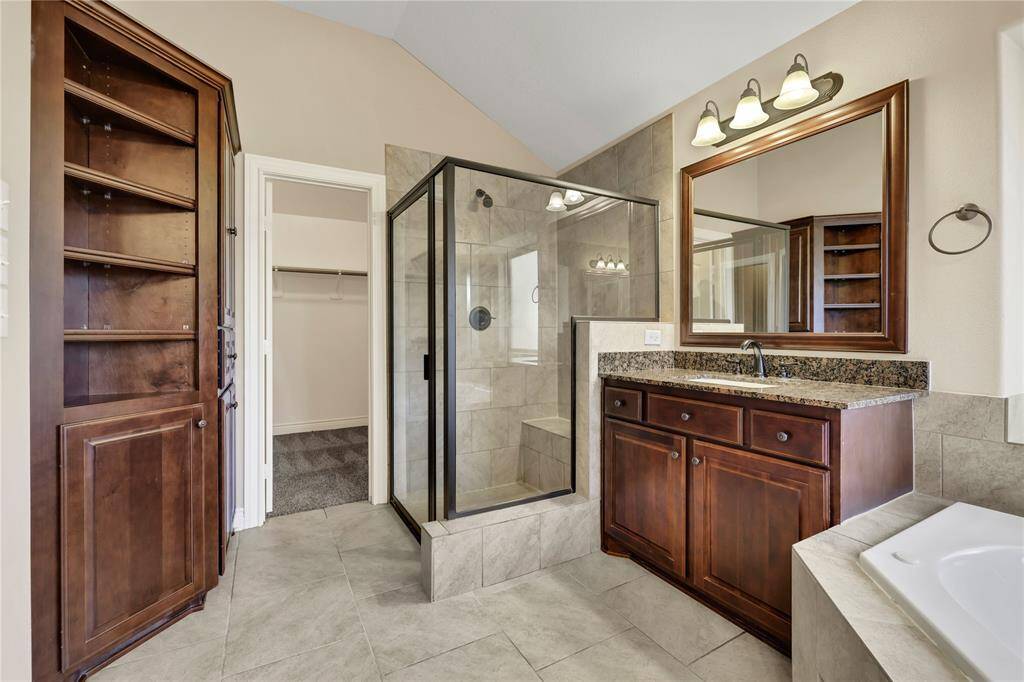 Primary ensuite with dual sinks, corner tub and separate shower