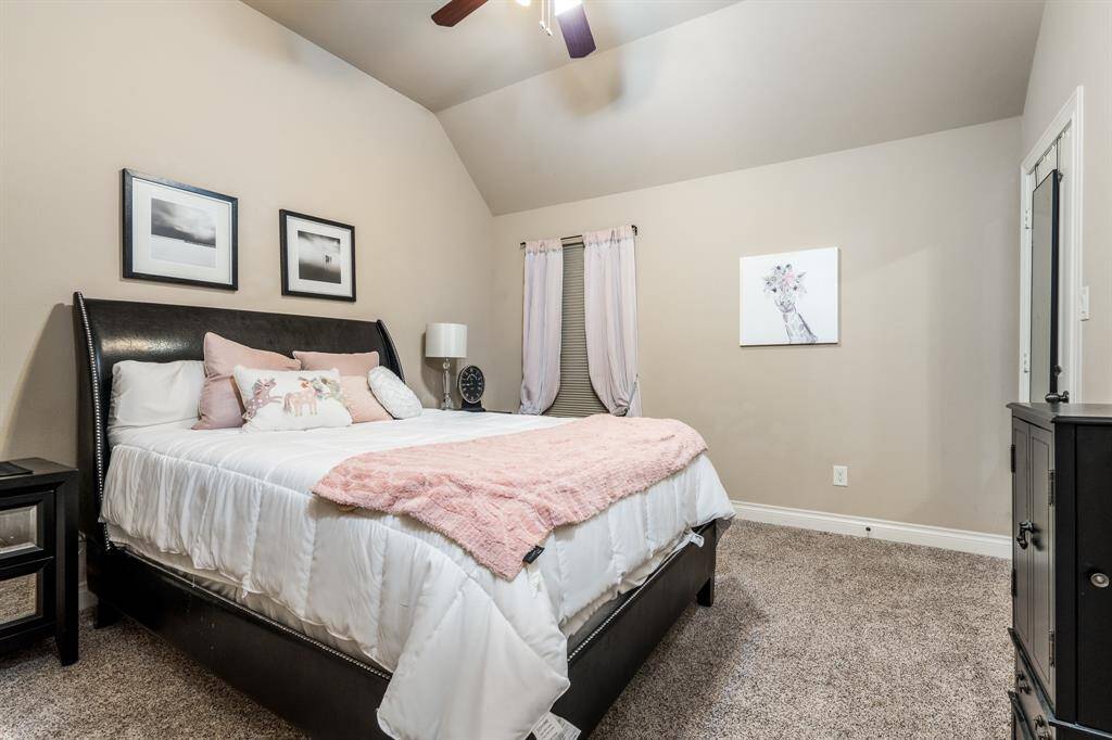 Another secondary bedroom with carpet, ceiling fan, and large window.