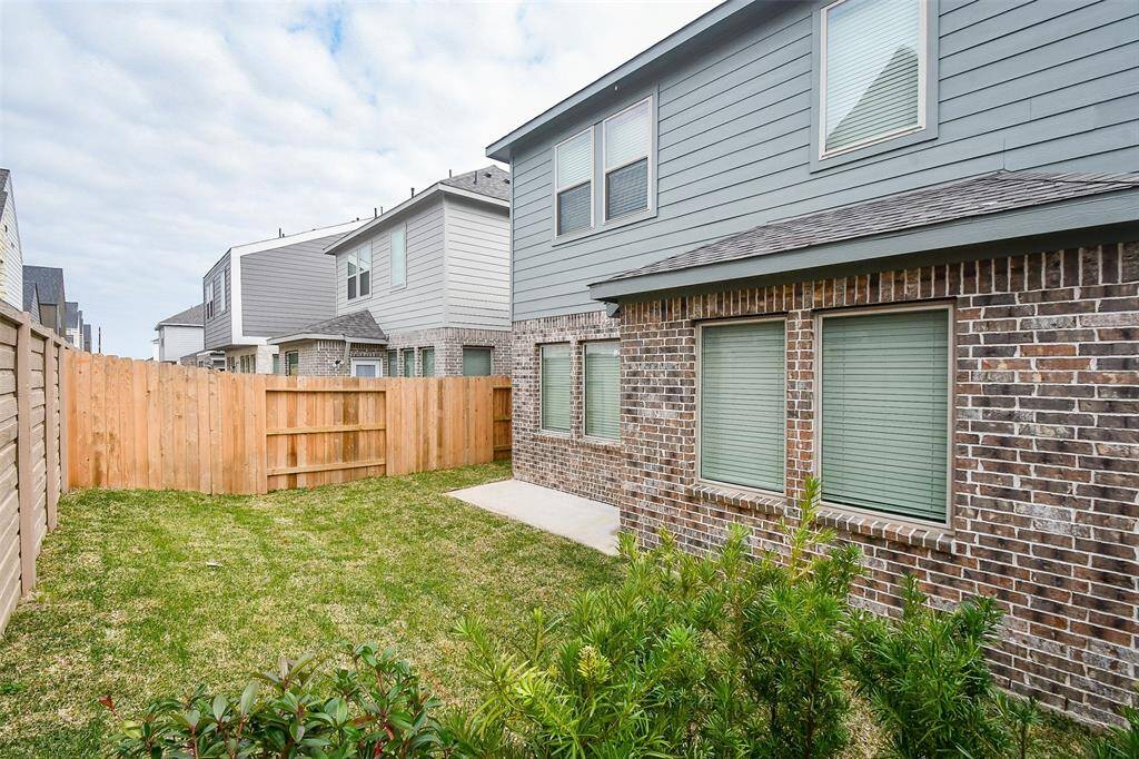 The fenced backyard provides a safe and enjoyable outdoor space, complemented by the lush greenery surrounding the property.