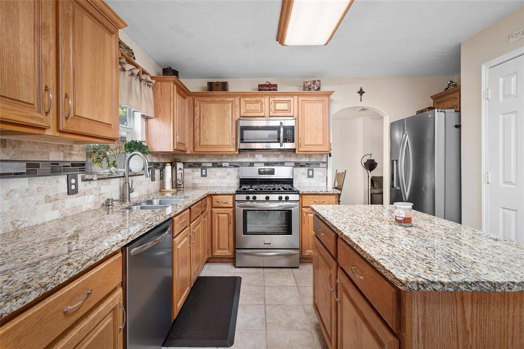 Your new kitchen features natural wood cabinetry, granite countertops, and Frigidaire Gallery stainless steel appliances.