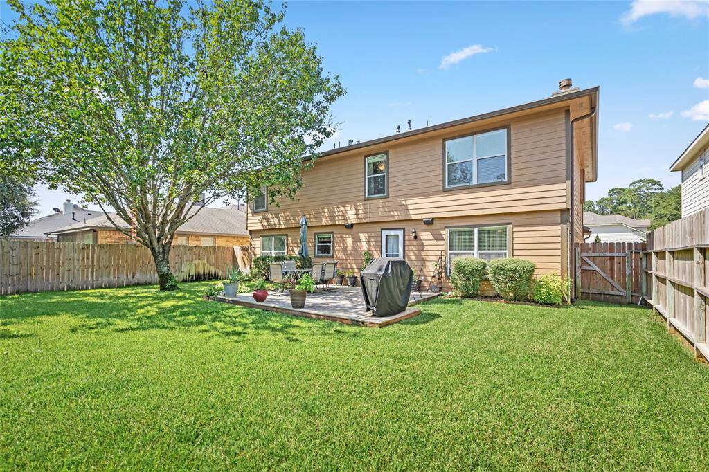 Your spacious backyard has a mature tree, well-maintained lawn, privacy fence, and a comfortable patio area.