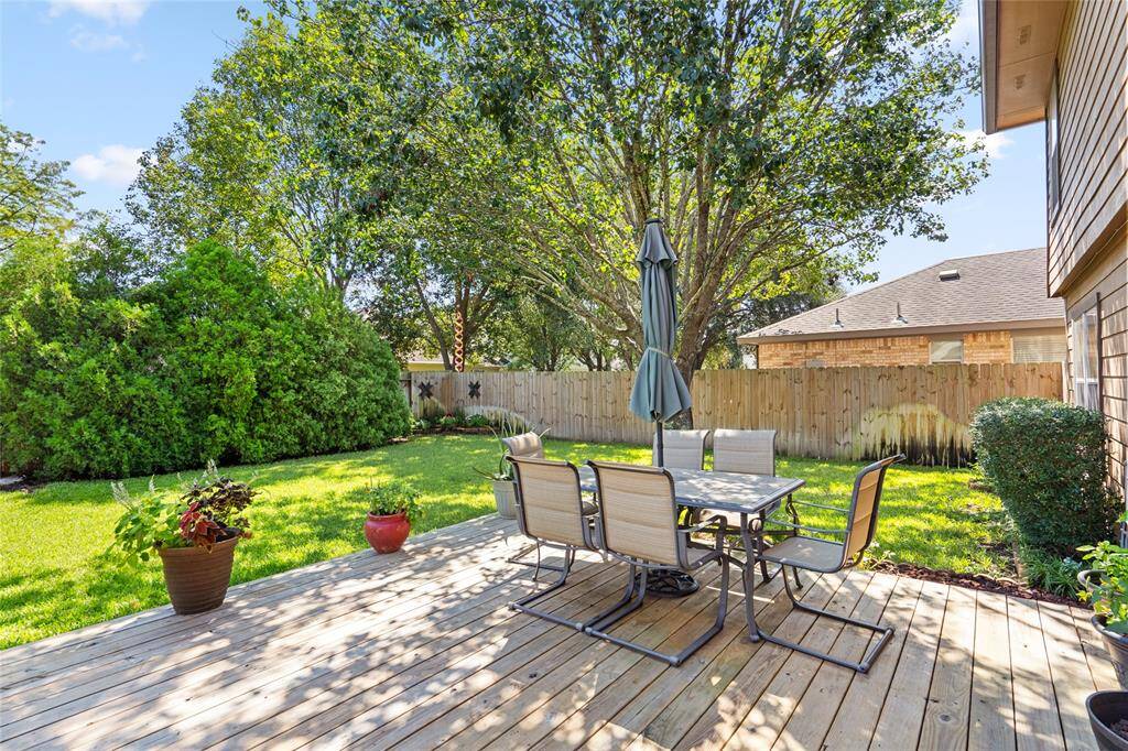 Another view of your wooden deck surrounded by lush greenery.